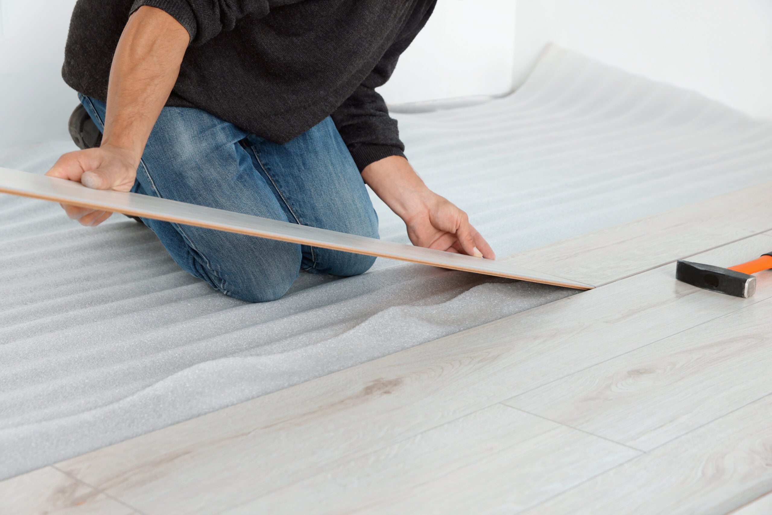 Worker installing new laminate flooring in room, closeup